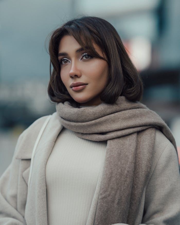 about-us-01 Stylish portrait of a woman in a scarf with a modern İstanbul backdrop.